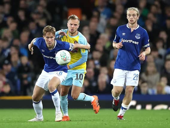 Everton's Kieran Dowell (left) and Rotherham United's David Ball (centre) battle for the ball during the Carabao Cup, second round match at Goodison Park