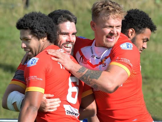 Happy - for now....Try scorer Josh Toole (centre) all smiles as he is congratulated by team-mates. Pic Steve Ellis