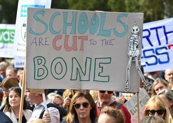 Headteachers from across England and Wales hold signs in Parliament Square, London, as they prepare to march on Downing Street to demand extra cash for schools. Picture: Kirsty O'Connor/PA Wire