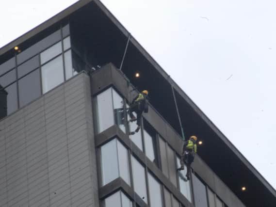 Structural engineers assess the loose cladding. Picture: Sam Cooper / The Star.