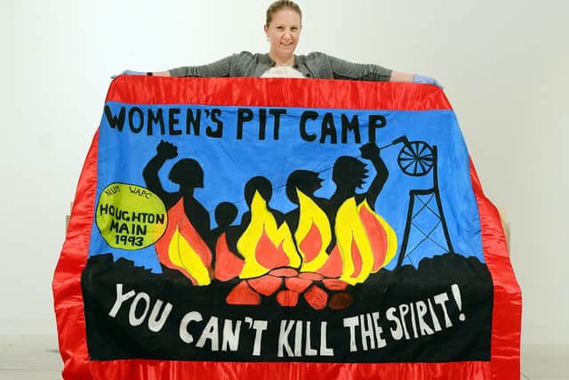 Museums Sheffield curator Louisa Briggs with a replica of the Sheffield Women Against Pit Closures banner, made for a display