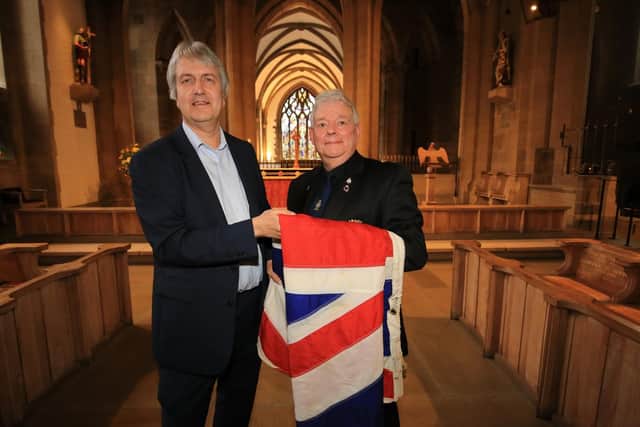 Installing a flag from HMS Sheffield at the Cathedral. Pictured are Kevan Shaw who donated the outstanding moeny needed to install the flag and Tanzy Lee from the HMS Sheffield Association.