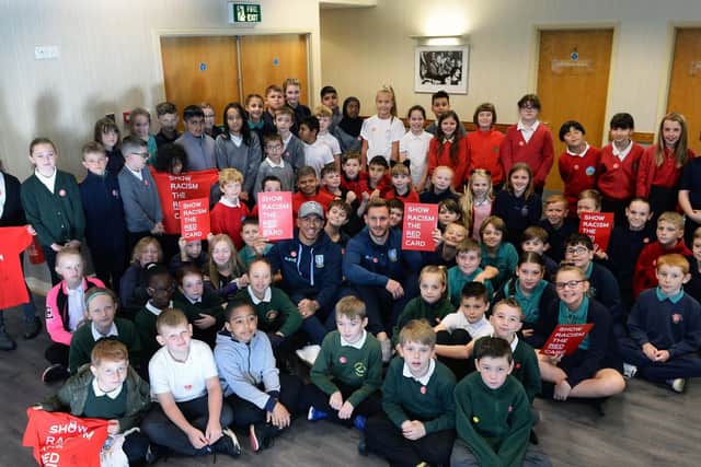 Pictured in amongst the pupils are Owls' player Liam Palmer and club skipper Tom Lees....Pic Steve Ellis