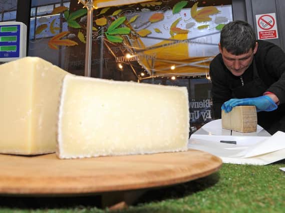 Nick Peck, of Porterbrook Deli, cuts some cheese at the first cheese festival at the Moor Market.