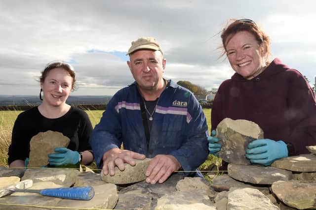 Andy Norman teaching Alison Hart and Anne Robertson, who are charity winner, at a dry stone walling session.