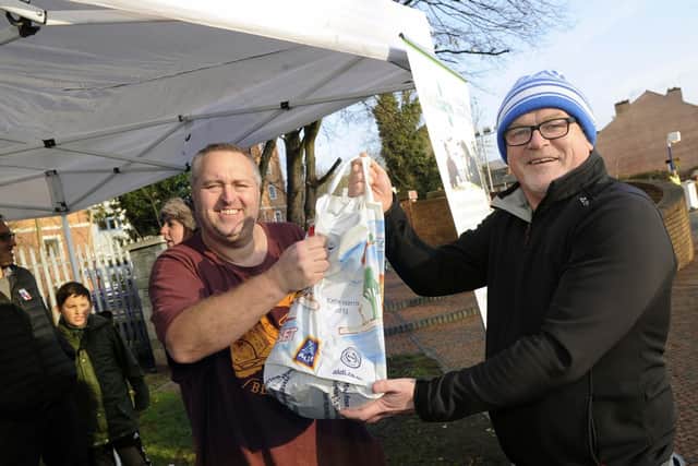 Owls fan Lee Townend, right, handing over a bag of food to Chris Hardy