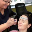 Staff at Graysons Solicitors in Sheffield add a little glitter to their day in aid of the mesothelioma campaign they are involved with - Laura Barraclough adding a bit of sparkle to Anne Rogers