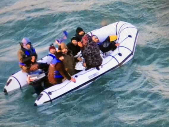 This image provided by the Marine Nationale (French Navy) shows migrants aboard a rubber boat after being intercepted by French authorities, off the port of Calais, northern France, Tuesday, Dec. 25, 2018. French authorities have rescued eight migrants, including two children, whose engine failed as they tried to sneak across the English Channel to Britain. (Marine Nationale via AP)