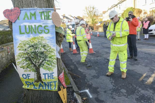 Workers from Amey prepare the road around a tree on Chatsworth Road in sheffield for remedial work