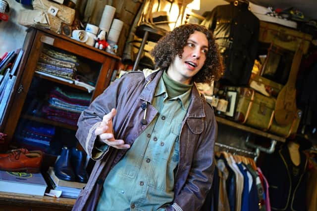 Jojo welcomes people who bring in old clothes into the shop for sale.