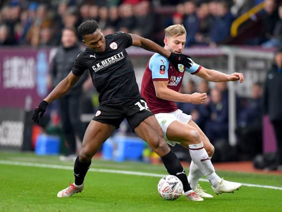 Barnsley's Dimitri Cavare (left) and Burnley's Charlie Taylor (right) battle for the ball