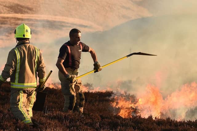 Firefighters tackle a blaze on moorland above Marsden, northwest England on February 27, 2018. Photo by Oli SCARFF / AFP/Getty Images)