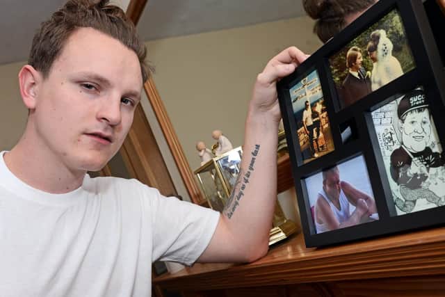 Lewis with photos of his adoptive parents