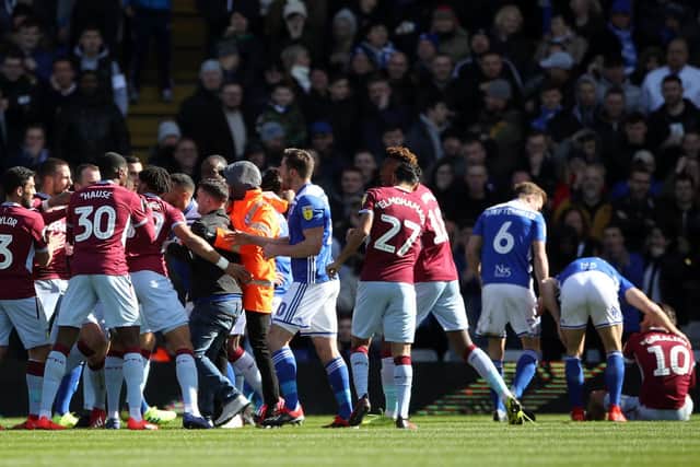 Paul Mitchell being restrained after attacking Aston Villa's Jack Grealish on the pitch (right) during the Sky Bet Championship match at St Andrew's Trillion Trophy Stadium, Birmingham. Picture: Nick Potts/PA Wire