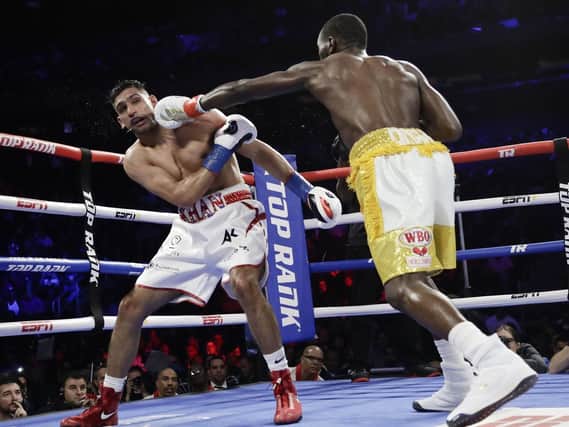 Terence Crawford, right, punches England's Amir Khan during the fifth round of a WBO world welterweight championship boxing match Sunday, April 21, 2019, in New York. Crawford won the fight.