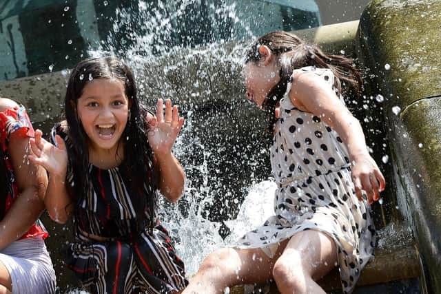 Romana Jabrana and Vanesa Ratra enjoy the cooling water in Sheffield's Peace Gardens