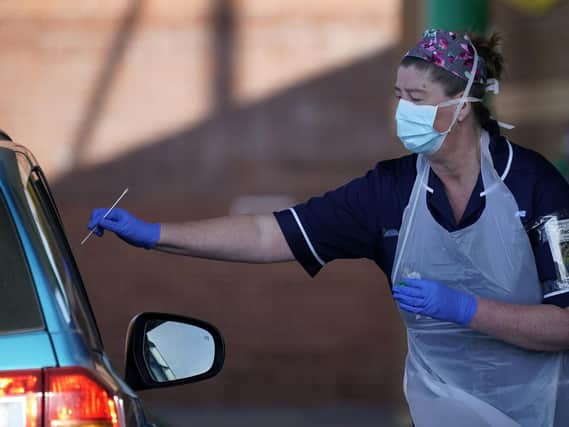 Nurses instruct and help NHS workers as they self swab for coronavirus at a drive through testing site in Sheffield.