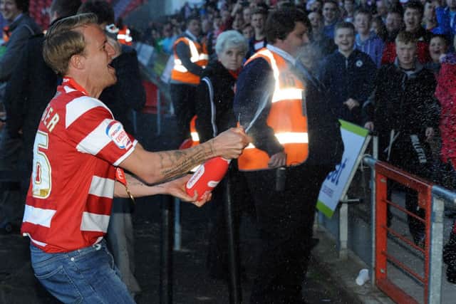 Doncaster Rovers James Coppinger sprays champange into the crowd as they celebrate the presentation of the nPower League One Trophy. Picture: Andrew Roe