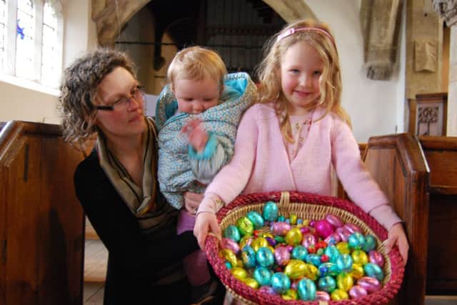 An Easter-themed coffee morning with hot cross buns and a childrens Easter egg hunt in All Saints Church raised £230 for Church funds. Pictured is Rachel Bowes with children Erin (centre) and Emily and some of the Easter eggs to be won.