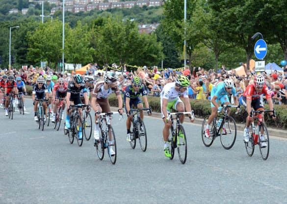 Tour riders race past Meadowhall.