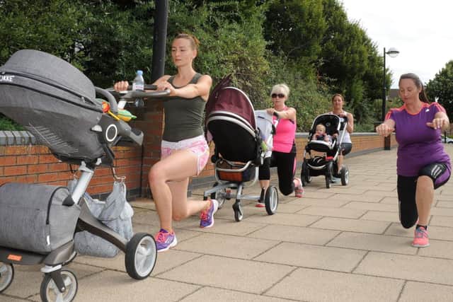 Instructor Jenna Caughey does lunges with mums as they take part in a bouncing buggies exercise calss at Lakeside. Picture: Andrew Roe