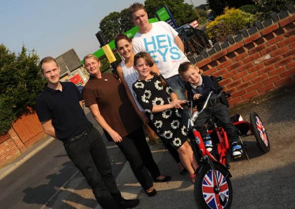 Leo Palmer, three, of Epworth on his new trike with (l-r) his physio Daniel Woods, Leesa Sharpe, Siobhan Edge, Casey Edge, 10, and Rick Palmer. Picture: Andrew Roe