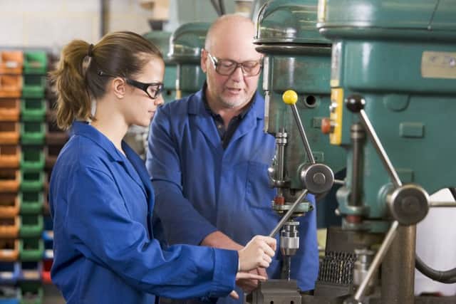An apprentice working with her mentor in a factory
