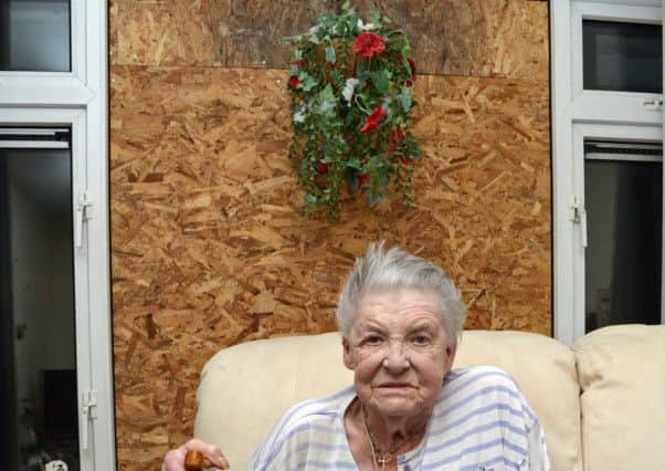June Green, pictured by her window that was smashed by a breeze block. Picture: Marie Caley