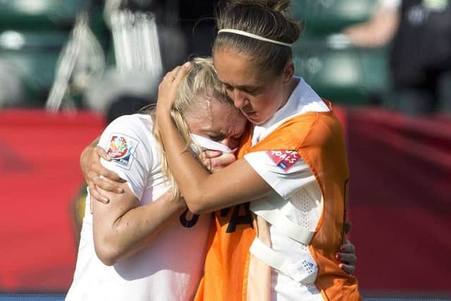 England's Josanne Potter, right, consoles Laura Bassett after defeat to Japan