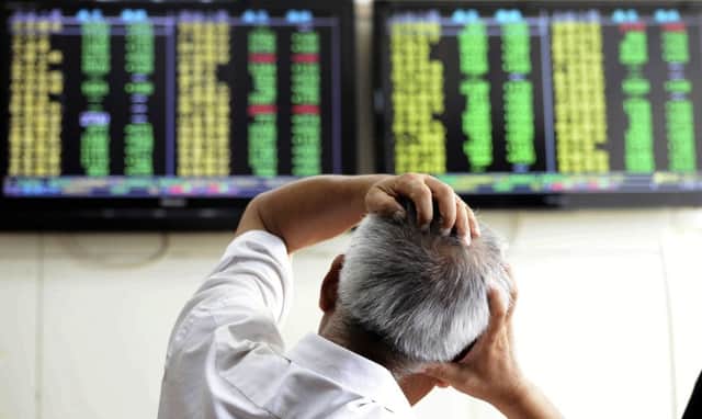 A Chinese stock investor reacts near a display for stock prices at a brokerage house in Qingdao in eastern China's Shandong province Tuesday, Aug. 25, 2015. Chinese stocks tumbled again Tuesday after their biggest decline in eight years while most other Asian markets rebounded from a day of heavy losses.