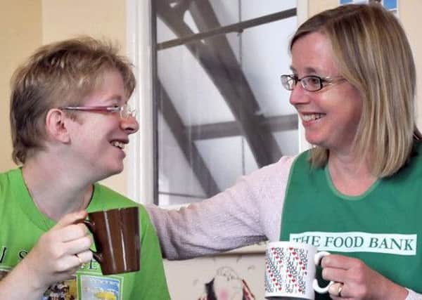 A volunteer at Sheffield S6 Foodbank enjoys a friendly chat with a client