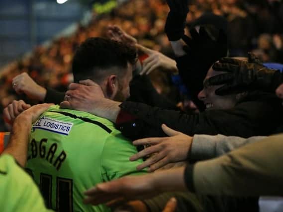David Edgar celebrates with fans after his late winning goal against Colchester United