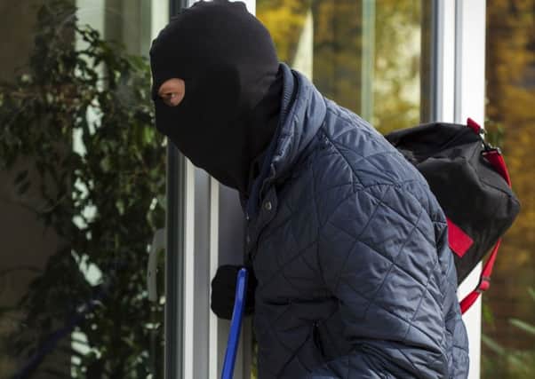 A generic photo of burglar attempting to gain entry to a house.