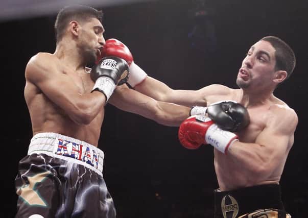 Amir Khan, left, trades punches with Danny Garcia, during their WBC and WBA junior welterweight title boxing match, Saturday, July 14, 2012, in Las Vegas. Garcia won the bout.