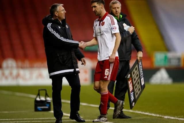 Nigel Adkins shakes hands with the injured Chris Basham as the midfielder is substituted