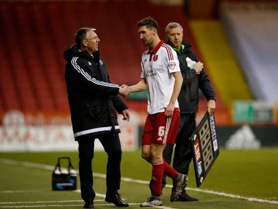 Nigel Adkins shakes hands with the injured Chris Basham as the midfielder is substituted