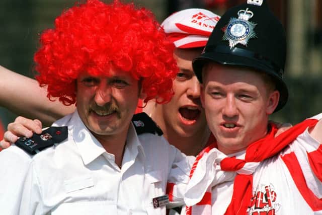 Police and Danish Fans swop Headgear in Hillsborough Park before Euro 96 clash between Croatia and Denmark.
