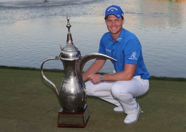 Danny Willett poses with his trophy after victory in the Dubai Desert Classic
