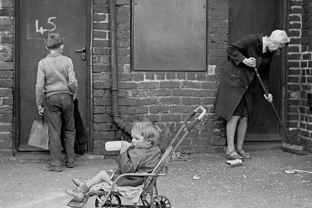 Mrs Tandy cleaning her backyard, Sheffield 1969 36-10. Image taken by Nick Hedges for homeless charity Shelter.