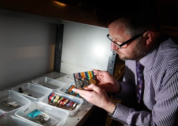 A collection of over 1000 military medals is being sold by the Sheffield Auction Gallery. Pictured is valuer John Morgan taking a look through the collection.