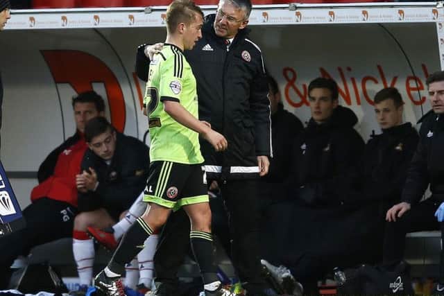 Nigel Adkins manager of Sheffield Utd congratulates Louis Reed of Sheffield Utd as he is substituted