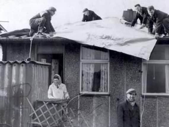 Residents of Skye Edge Avenue get a roof over their heads as workmen lay tarpaulin to protect their hurricane ravaged homes