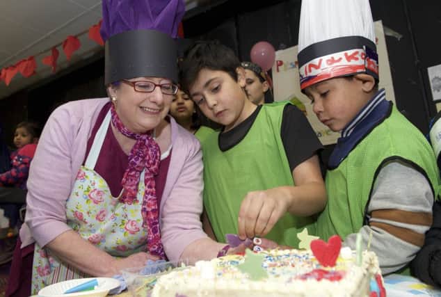 Burngreave Adventure Playground plays host to a cake decorating competition as part of a Bake Off event organised by Sarah kesteven who helps a couple of boys with their cake
Picture by Dean Atkins