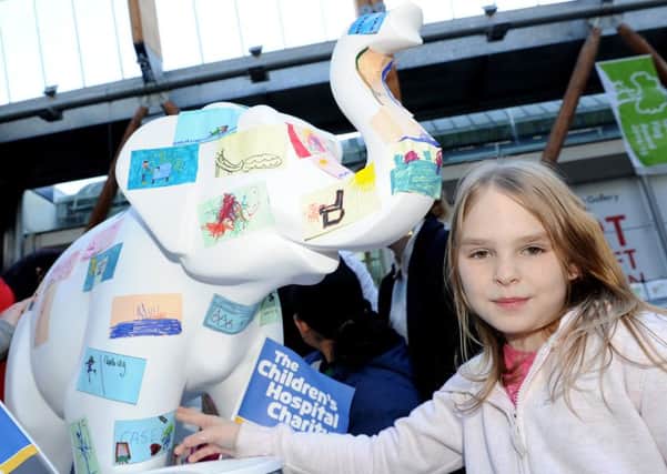 Casy Ellis, eight, places her picture on a elephant which is being decorated for Herd of Sheffield. Picture: Andrew Roe