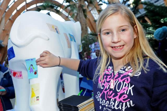 Jaime Grace, seven, places her picture on a elephant which is being decorated for Herd of Sheffield. Picture: Andrew Roe