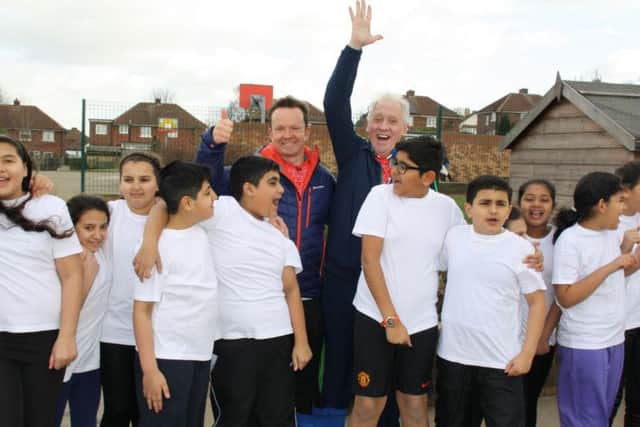 BBC Look Norths Paul Hudson (left) and Harry Gration (right), centre, prepare to walk three counties on 'three legs' for Sport Reliefwith a warm up today at St Anns Junior and Infant School in Rotherham.