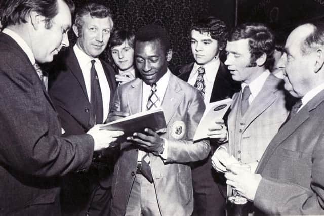 Pele signs an autograph for Star reporter Tony Pritchett, with Derek Dooley watching on