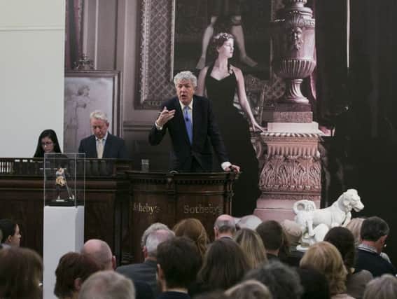 Auctioneer Henry Wyndham fields bids for items from the Dowager Duchess of Devonshire's collection at Sotheby's in London.