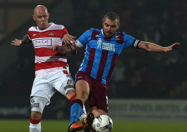 Richard Chaplow tussles with Stephen Dawson during last night's 2-0 defeat to Scunthorpe. Photo: Andrew Roe