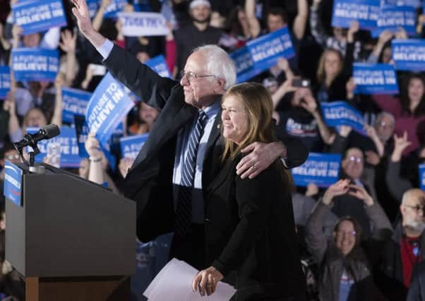 Democratic presidential candidate Sen. Bernie Sanders, I-Vt., center left, waves to the crowd with his wife Jane. (AP Photo/John Minchillo)